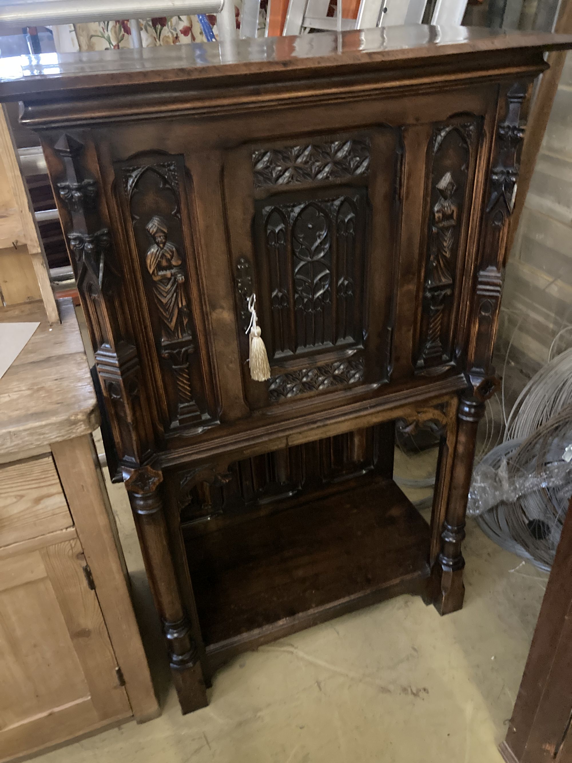 A medieval style carved walnut side cabinet, width 90cm, depth 44cm, height 140cm